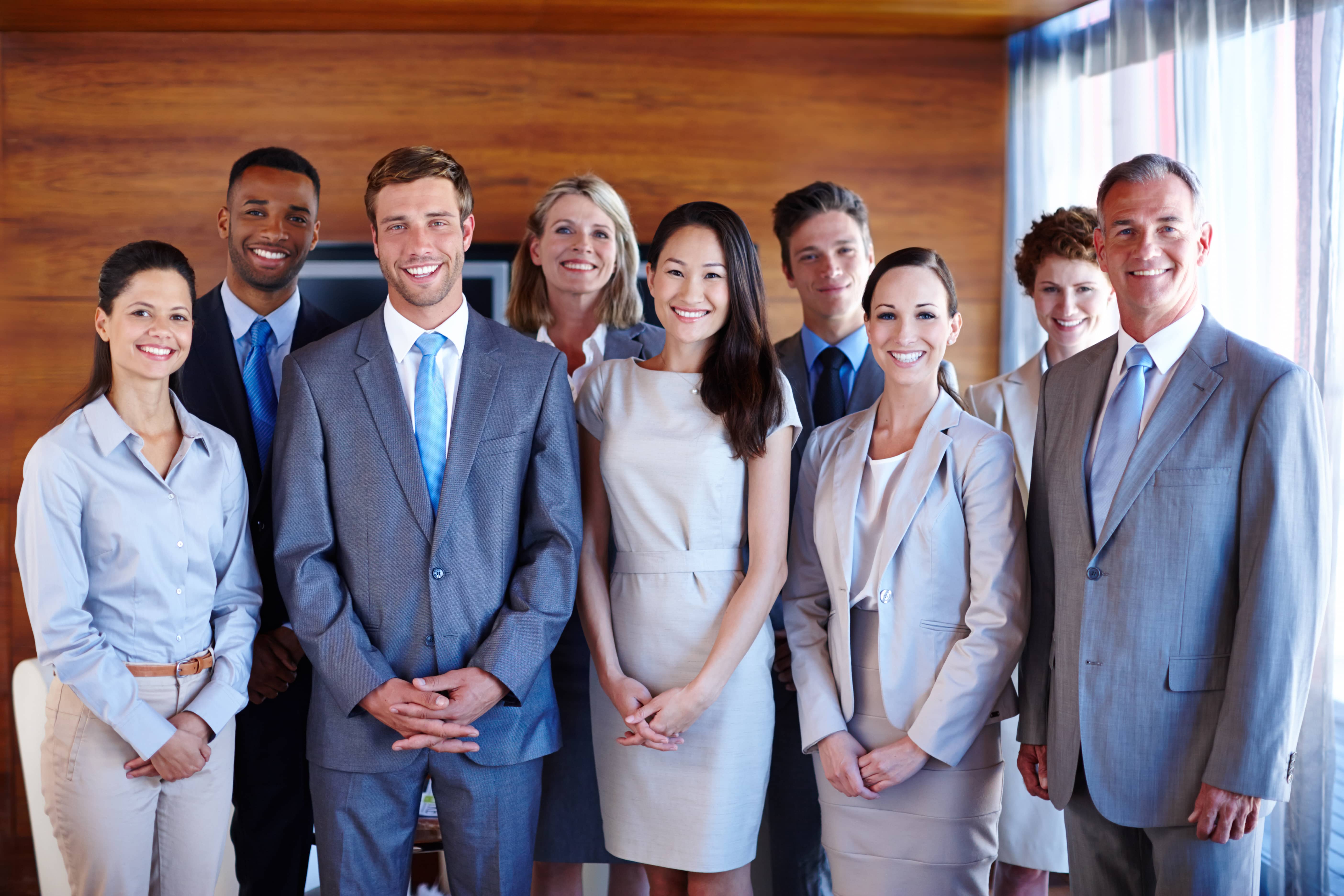 Men and women smiling in formal attire