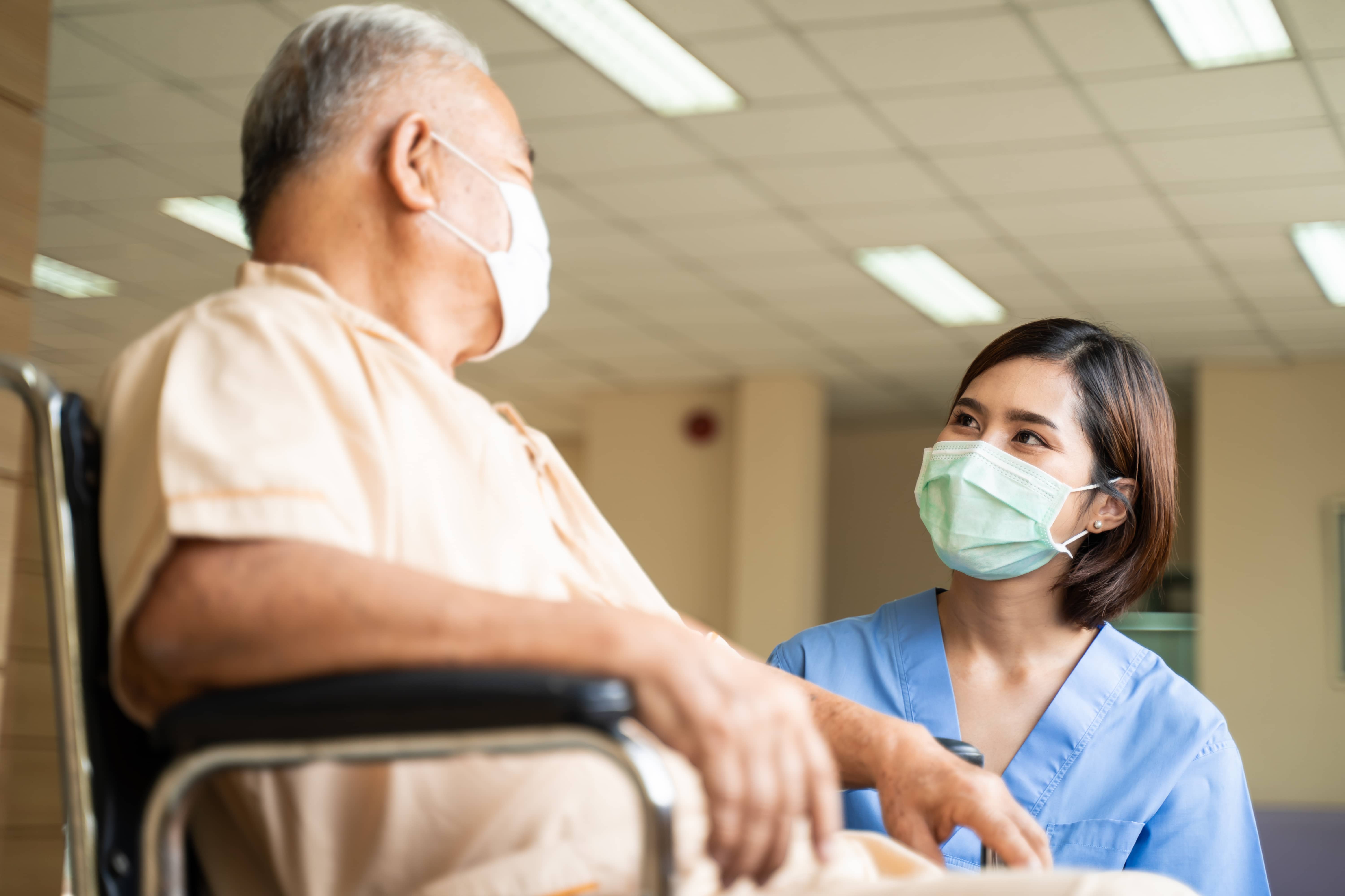 Travel nurse speaking to patient in wheelchair