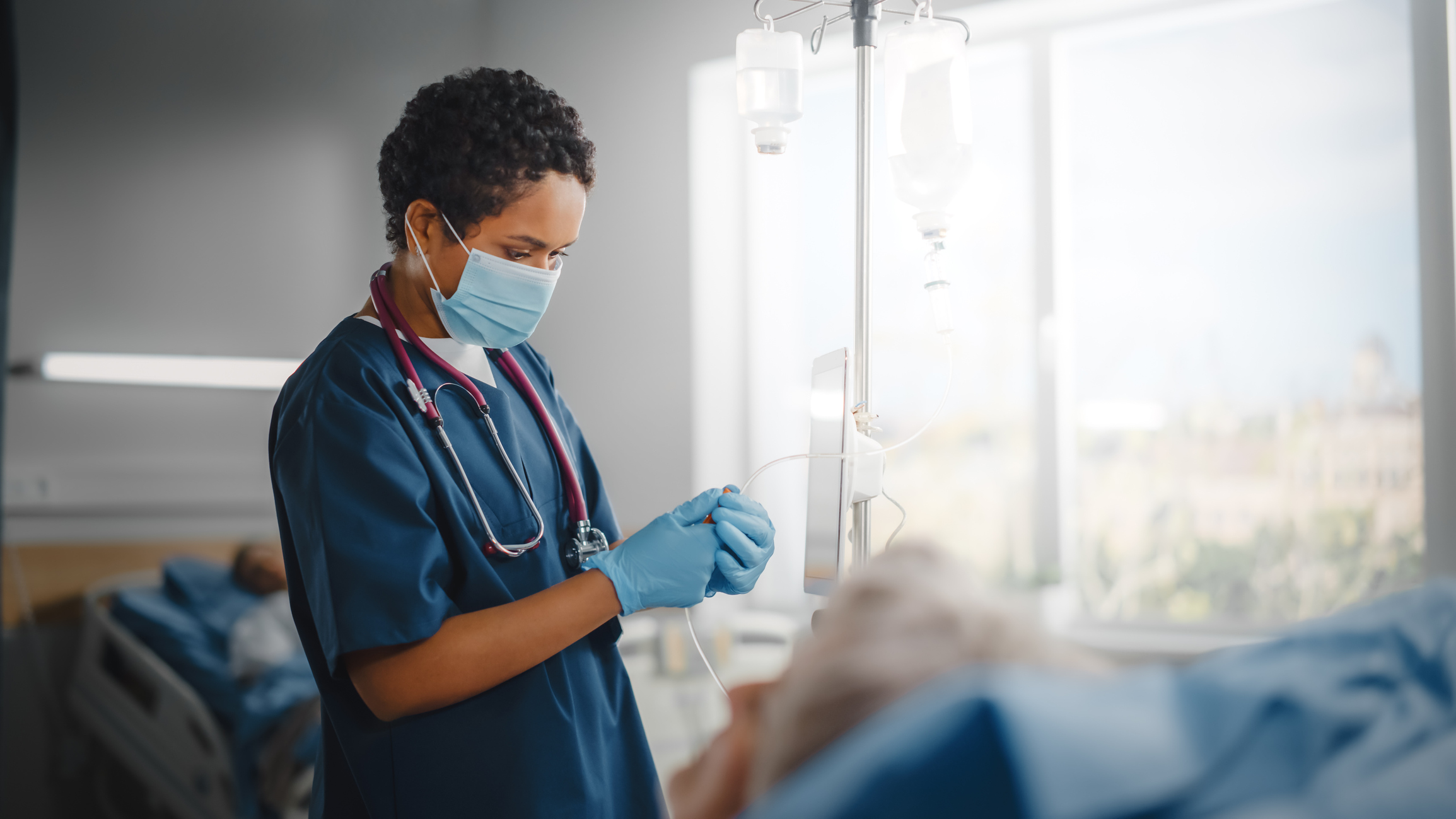 Travel Nurse hooking up a patients IV